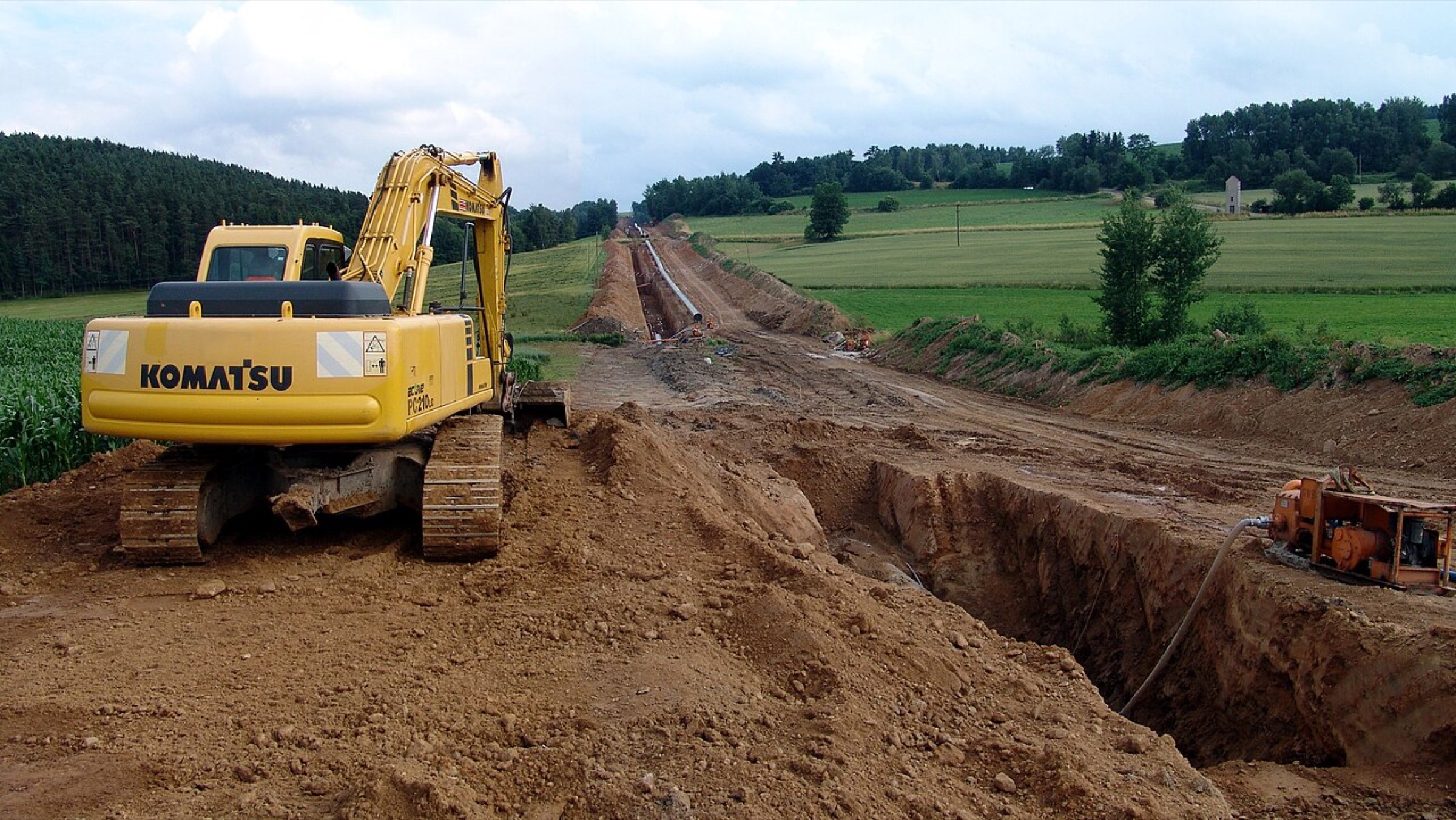 A coated transmission pipeline strung along an open right-of-way under construction
